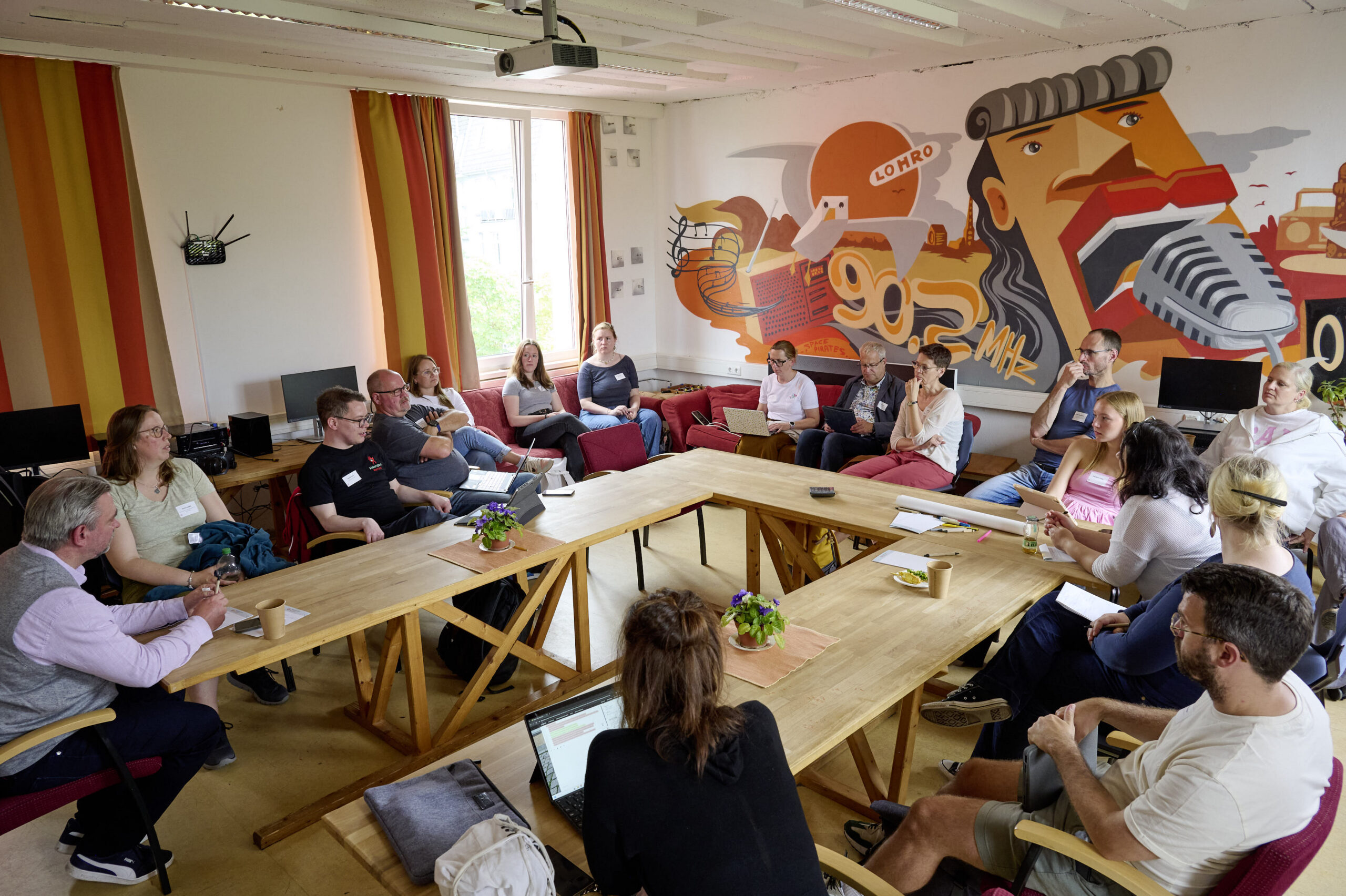 Teilnehmende eines LMB-MV-Workshops arbeiten gemeinsam an einem Tisch.
